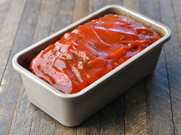 Spreading ketchup on top of meatloaf