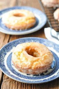 Close up image of a homemade old fashioned donut on a blue and white plate