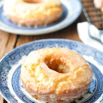 Close up image of a homemade old fashioned donut on a blue and white plate