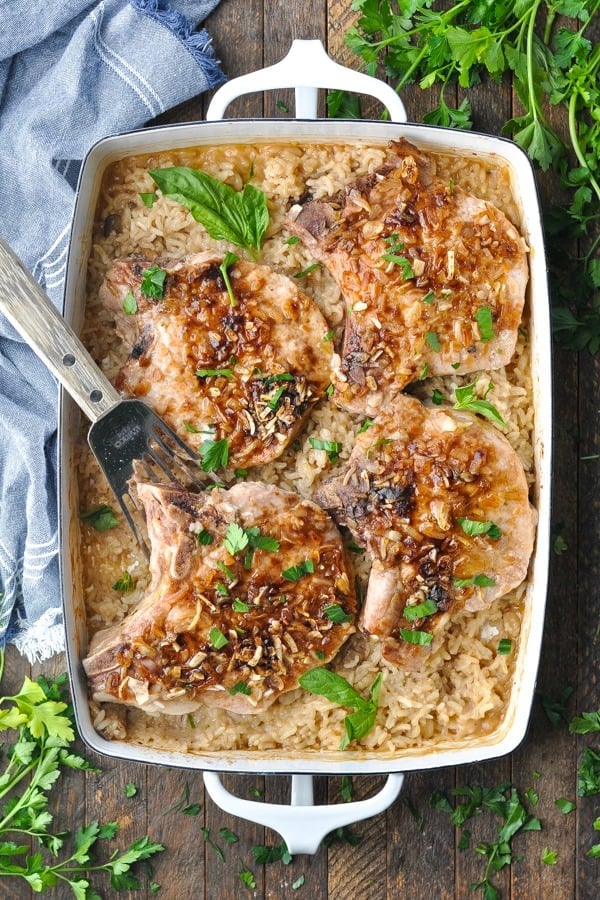 Overhead shot of a casserole dish with baked pork chops and rice