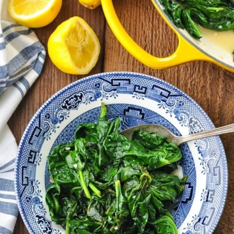 Close overhead shot of a bowl of sauteed spinach with garlic and fresh lemon