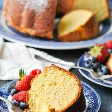 Slice of sour cream pound cake on a blue and white plate with fresh berries