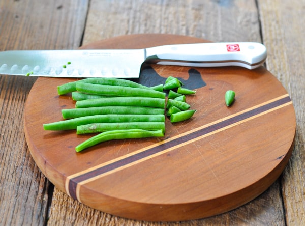 Cutting green beans on a cutting board