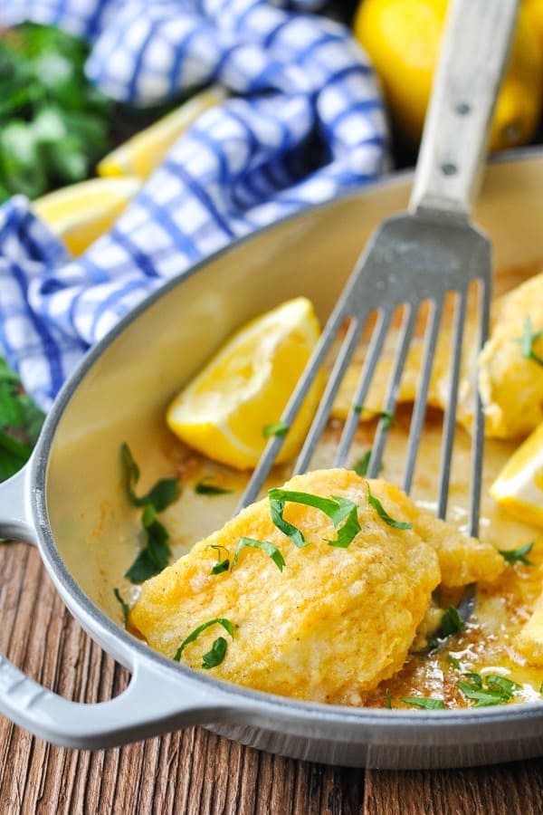Close up front shot of crispy baked cod with a serving spatula