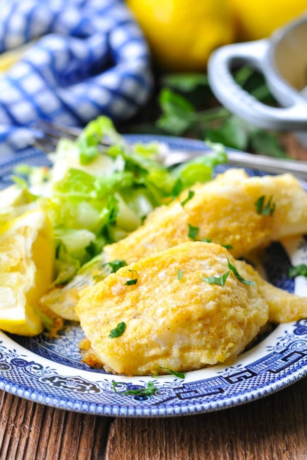 Baked Cod with butter and lemon on a blue and white plate