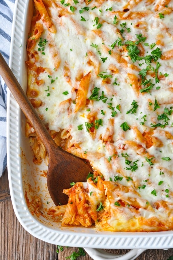 Close overhead shot of a baked penne casserole in a white dish
