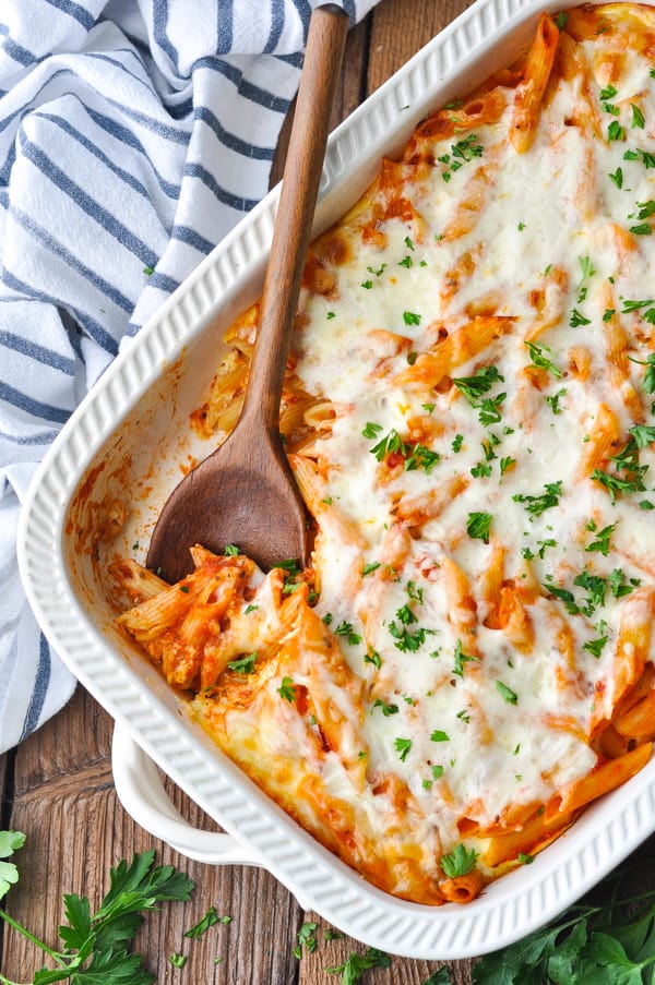 Diagonal overhead image of baked penne pasta in a white dish