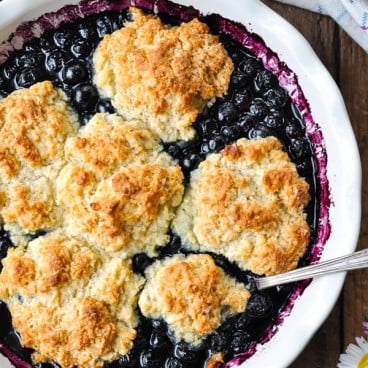 Overhead shot of an old-fashioned blueberry cobbler recipe baked in a white pie dish