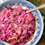 Overhead image of braised red cabbage in a blue and white serving bowl