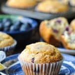 A homemade bakery style easy blueberry muffin on a blue an white plate