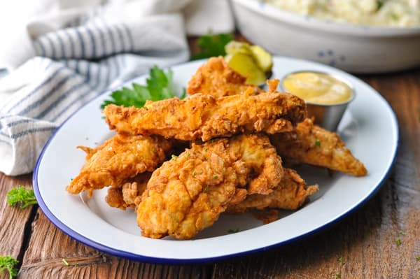 Horizontal shot of a plate of homemade crispy fried chicken fingers
