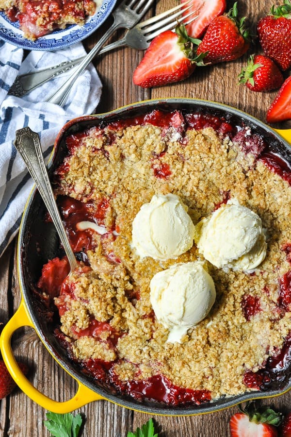 Overhead shot of Skillet Strawberry Crisp on a wooden surface
