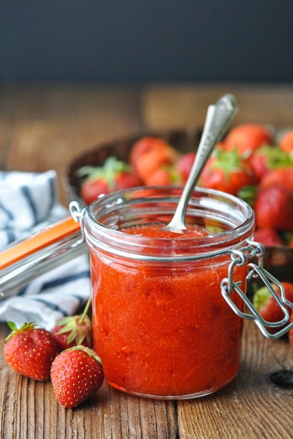 Side shot of a spoon inside a jar of strawberry freezer jam