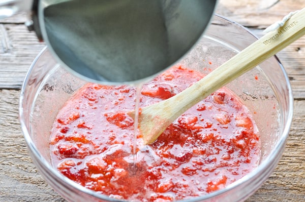 Adding pectin into strawberries for jam
