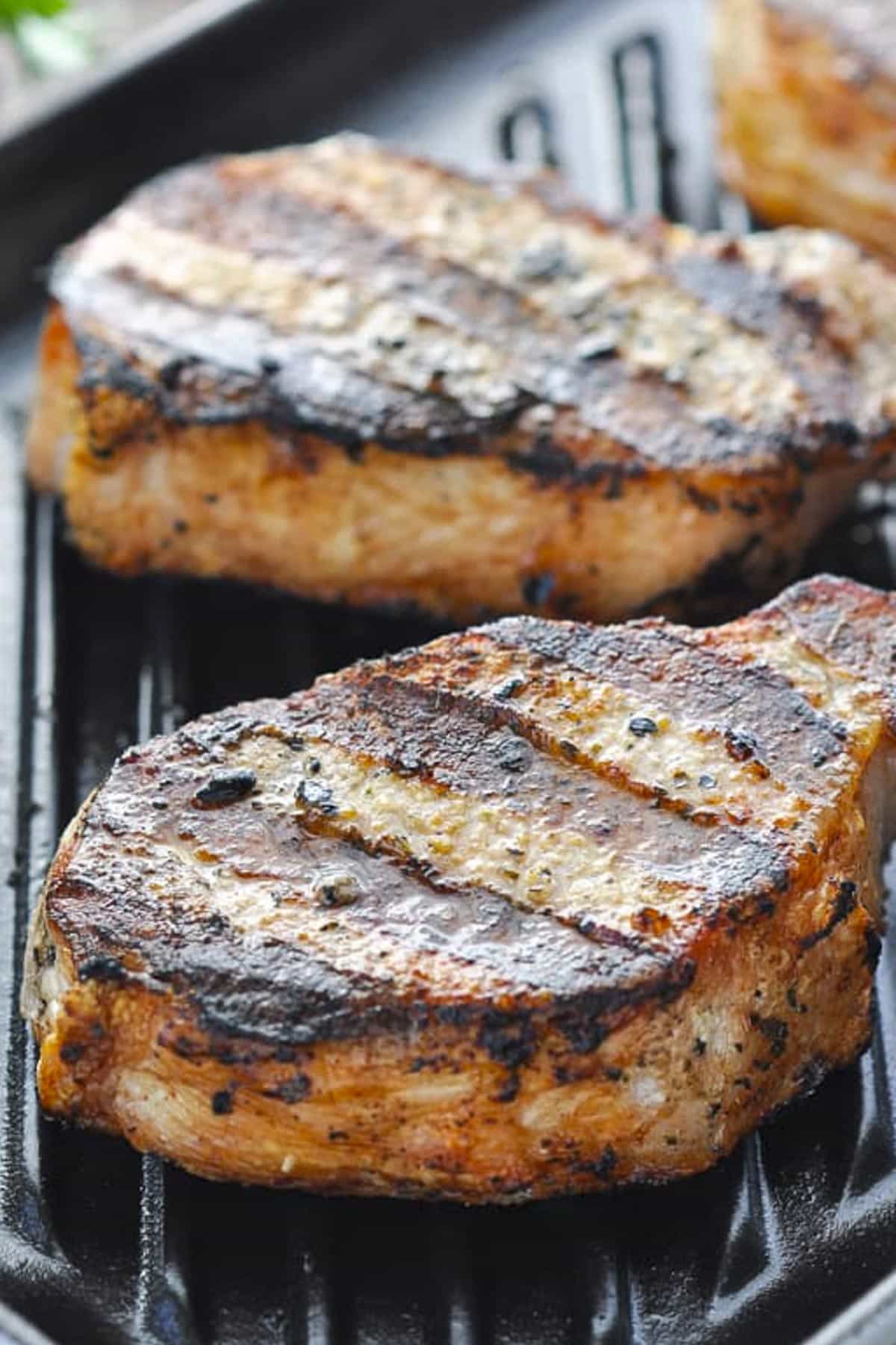 Side shot of one of the best grilled pork chop recipes on a grill.