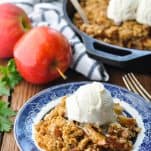 Front shot of serving of apple crisp on a blue and white plate