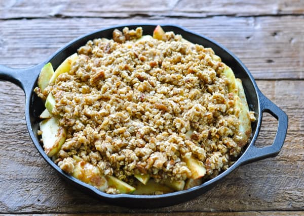 Adding topping to an apple crisp skillet before baking