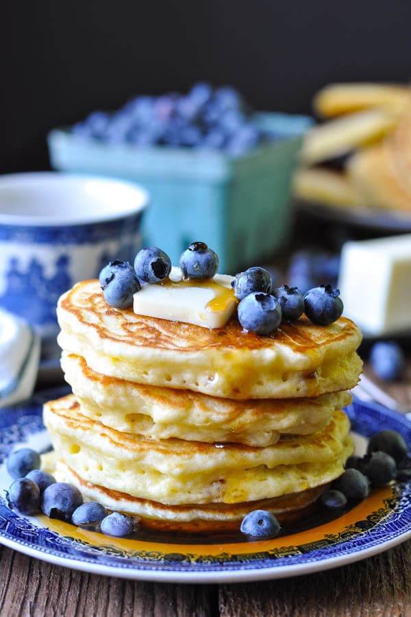 Stack of four blueberry pancakes on a blue and white plate