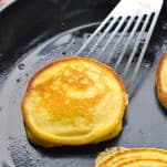Close up shot of hoe cakes in a cast iron skillet with a spatula