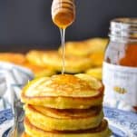 Front shot of honey drizzling on top of a stack of hoe cakes