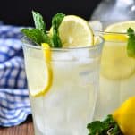Close up shot of fresh squeezed lemonade with ice lemon slices and mint in a glass