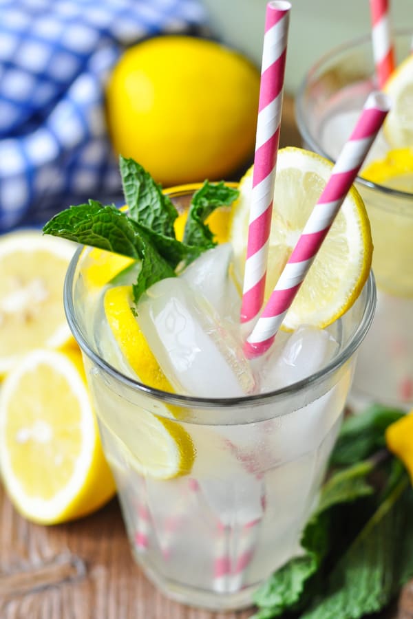 Close up shot of a glass of homemade lemonade with two pink and white striped straws