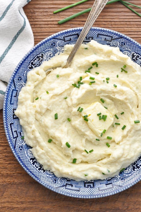 Close overhead image of a serving spoon in a bowl of mashed cauliflower