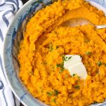 Close overhead shot of sweet potato mash with butter and parsley on top