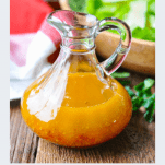 Front shot of a bottle of homemade pepper jelly vinaigrette salad dressing with a text title below the image