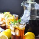 Front shot of a pitcher and glasses of sweet tea with a black backdrop