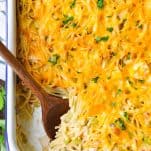 Close overhead shot of chicken spaghetti casserole with a wooden serving spoon