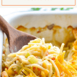 Close up shot of a wooden spoon scooping up chicken spaghetti from a casserole dish with a text title box at the top