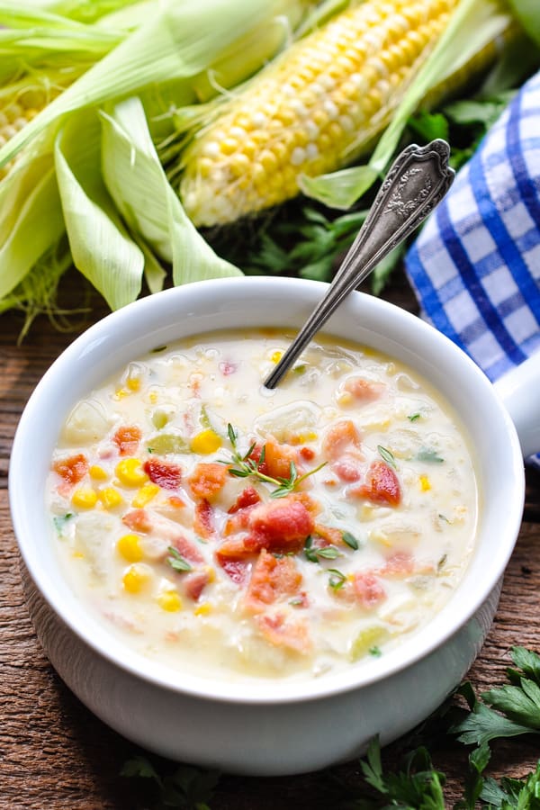 Side shot of a spoon in a bowl of corn chowder