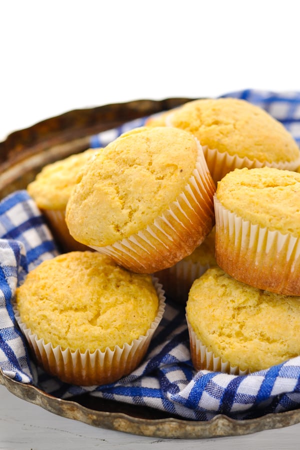 Light and fluffy homemade buttermilk corn muffins in a basket on a white table