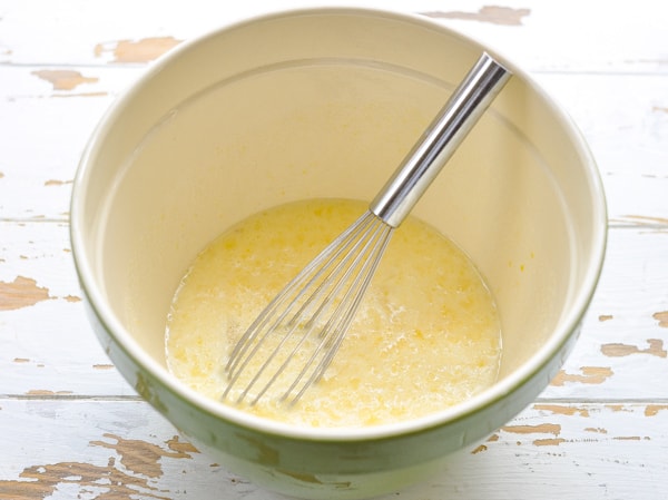 Wet ingredients for homemade cornbread muffins in a mixing bowl
