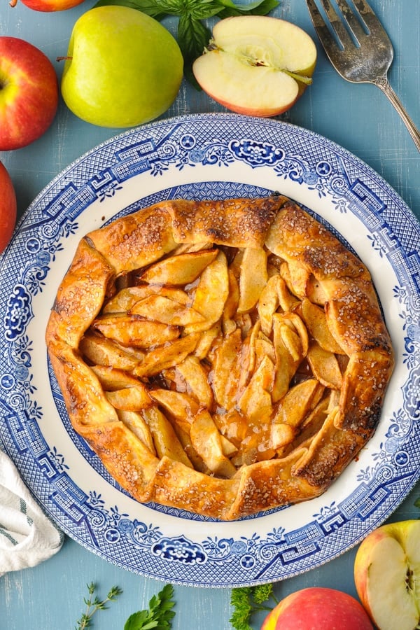 Overhead image of an apple galette on a blue table