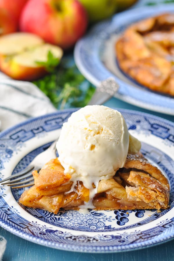 Slice of apple galette on a plate with ice cream on top