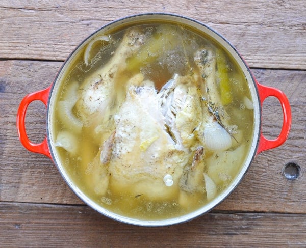 Whole chicken boiled in water to make homemade broth