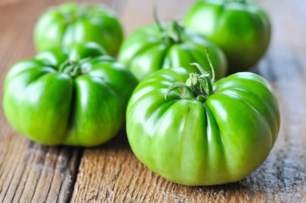 Green tomatoes on a wooden table