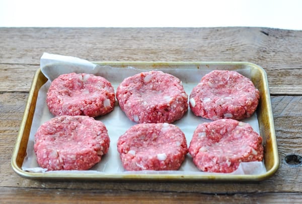 Hamburger patties on a tray before grilling