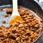 Sloppy Joe mixture in a skillet with a wooden spoon