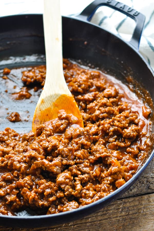 Sloppy Joe mixture in a skillet with a wooden spoon