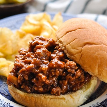 Front shot of a homemade sloppy joe sandwich on a blue and white plate