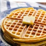 Plate of waffles with butter and syrup on top