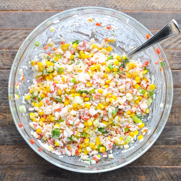 Overhead shot of stirring together rice salad in a glass bowl