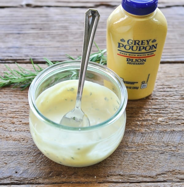 Mustard sauce for pork tenderloin in a glass bowl with a spoon