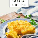 Serving of Southern baked mac and cheese on a blue and white plate with a text title box at the top