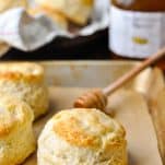 Tray of homemade biscuits with a jar of honey in the background