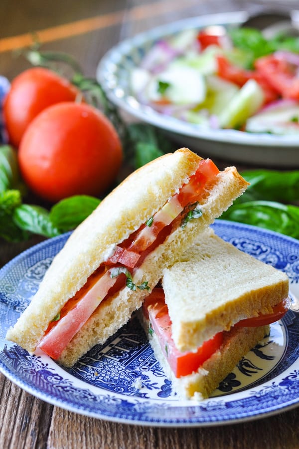 Sliced tomato sandwich stacked on a plate