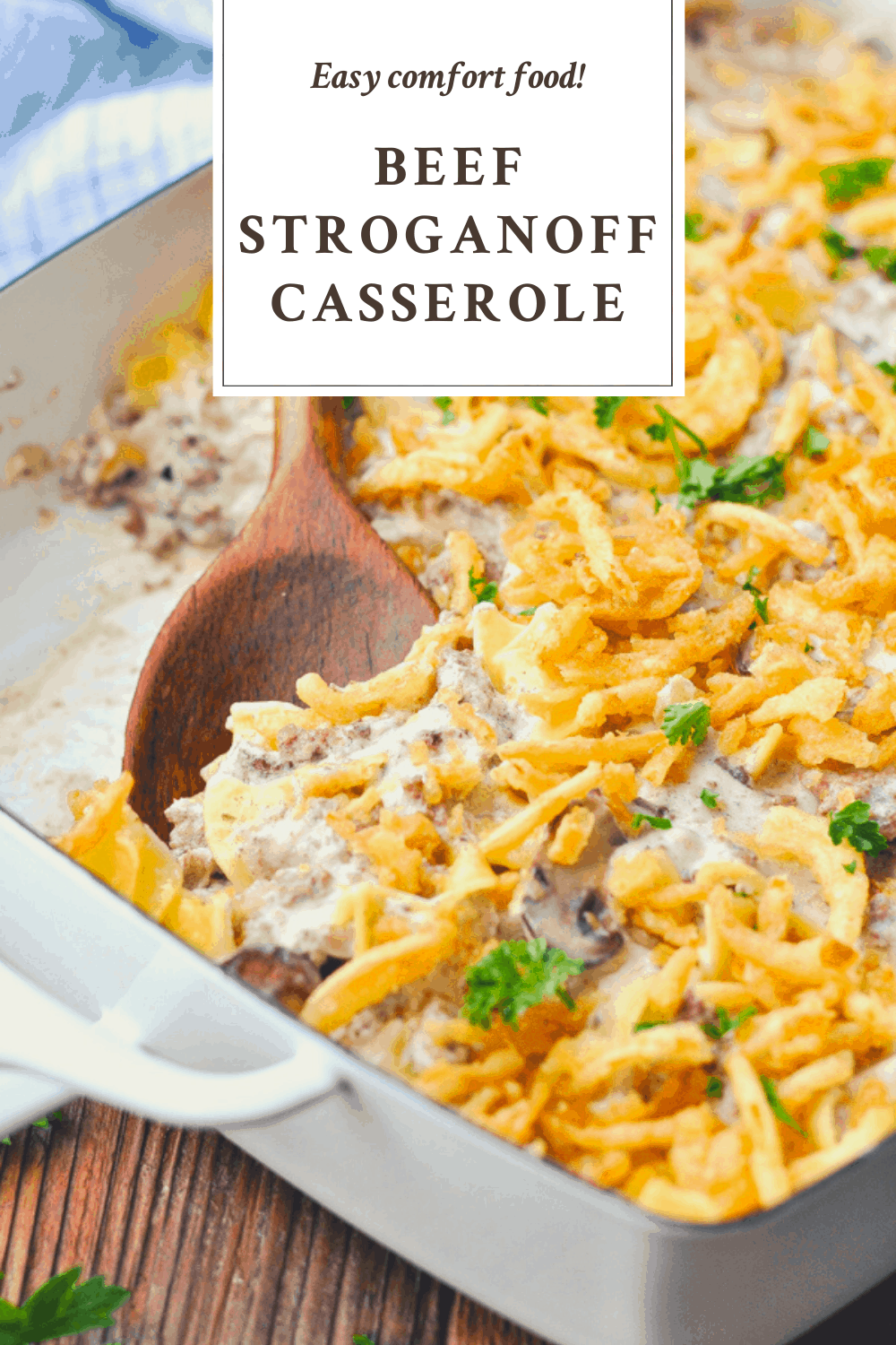 Close up shot of a wooden spoon serving beef stroganoff casserole with a text title box at the top